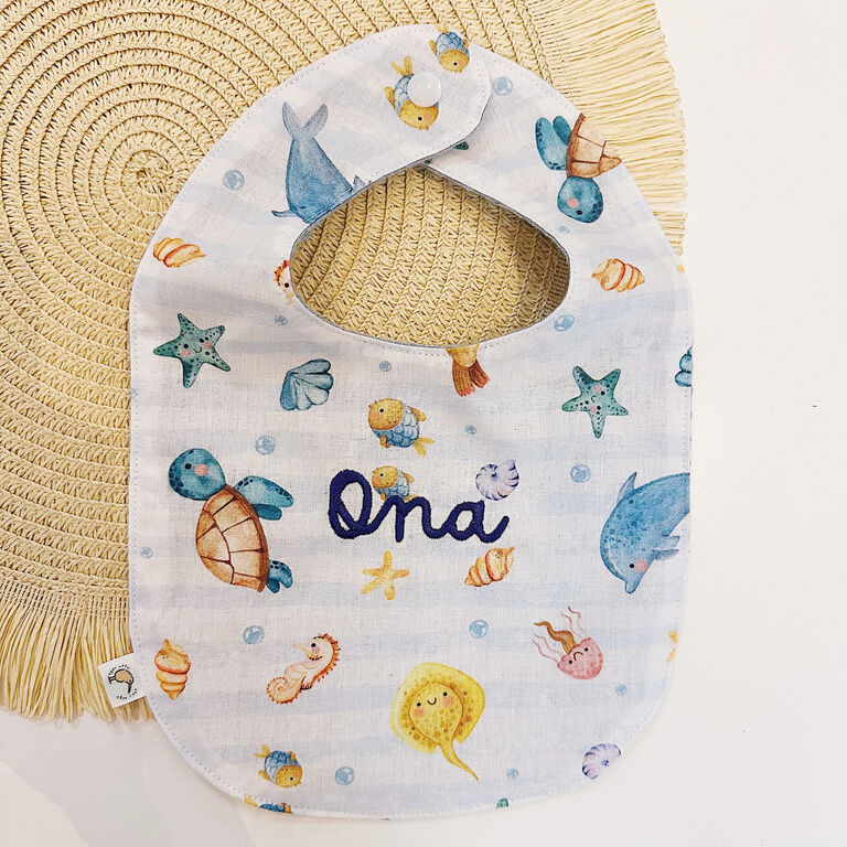 Babero de tela peces y rayas con nombre bordado