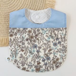 Babero de tela floral azul y azul celeste con nombre bordado